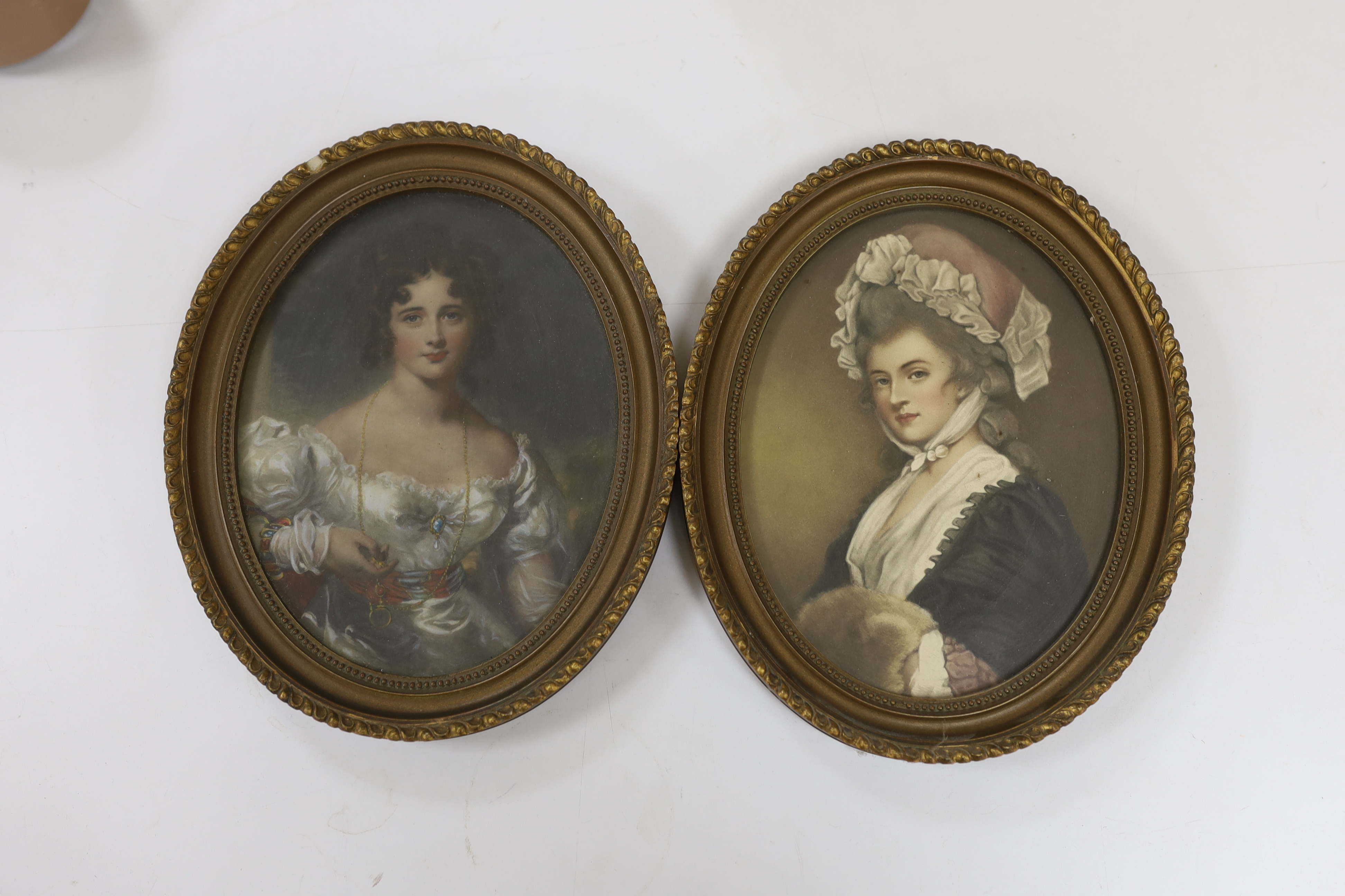 A pair of oval overpainted prints, ladies wearing Georgian dress, gilt framed, 22 x 16cm